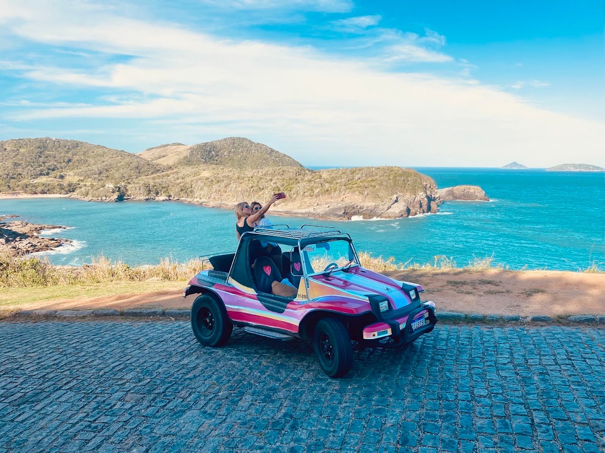 Turistas em um buggy colorido diante do mar de Búzios