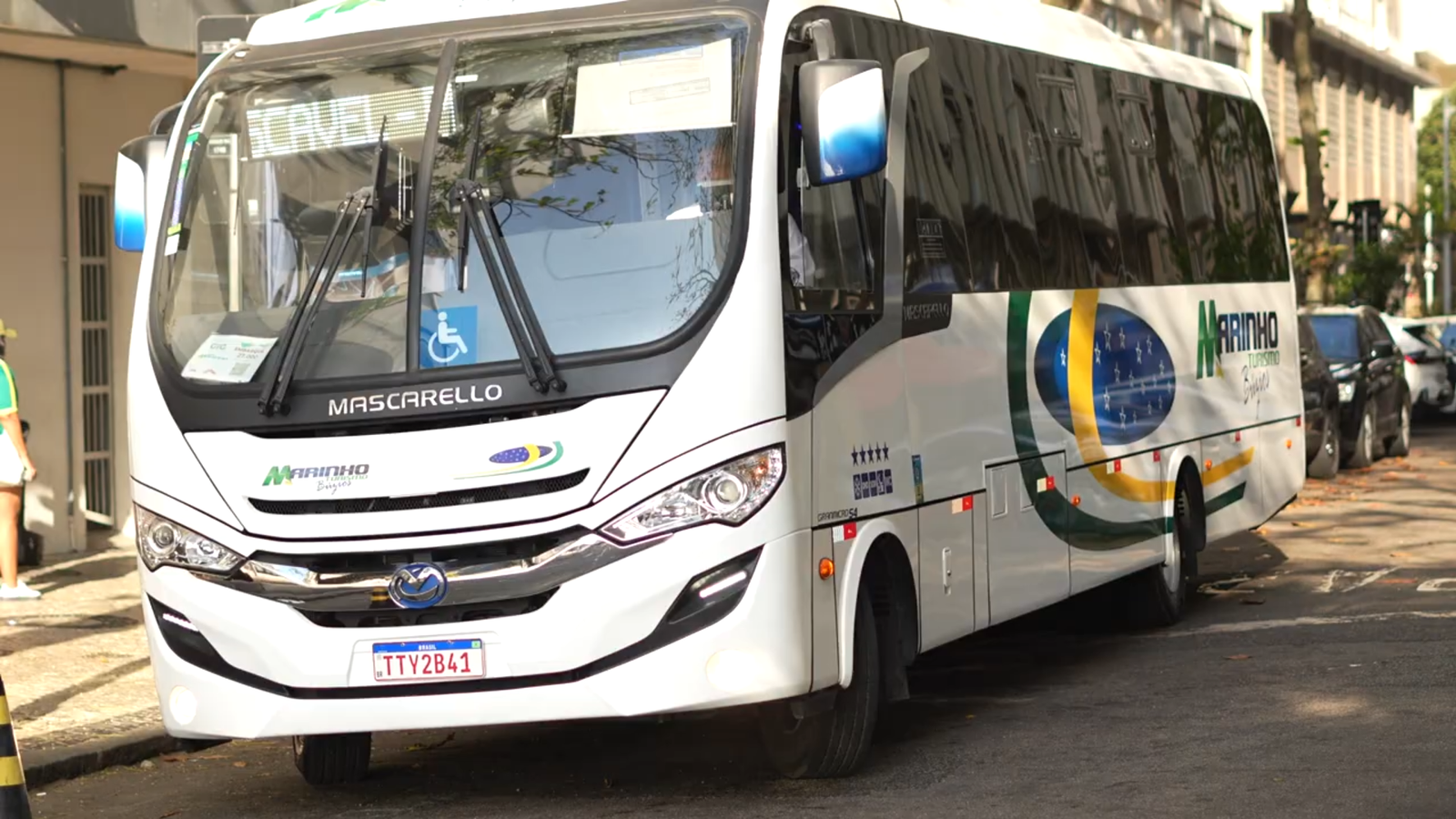 Motorista de transfer aguardando passageiro ao lado do veículo em Búzios